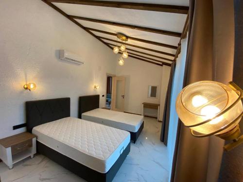 um quarto com duas camas e um candeeiro em Villa Mustafa em Fethiye