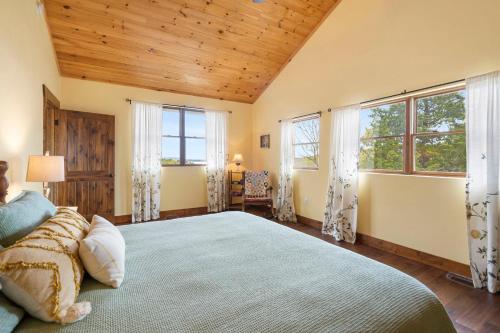 Un dormitorio con una cama grande y dos ventanas. en Mountain Estate Lake Front, en Blue Eye