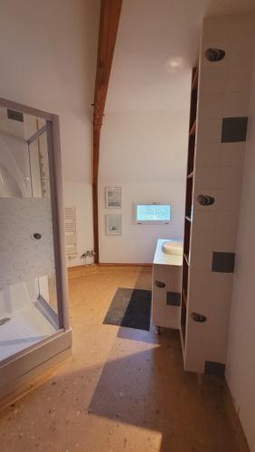 un baño vacío con lavabo y espejo en La maison ronde et ses 2 cahutes, en Monthoiron