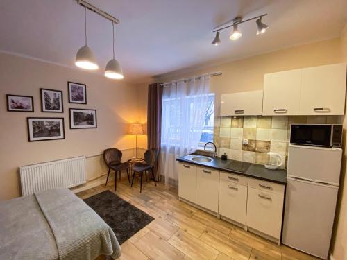 Habitación con cocina con cama y mesa. en Mokka Apartament en Varsovia