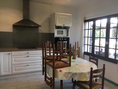 une cuisine avec une table et des chaises et un micro-ondes dans l'établissement Chez Loulou, à Léon