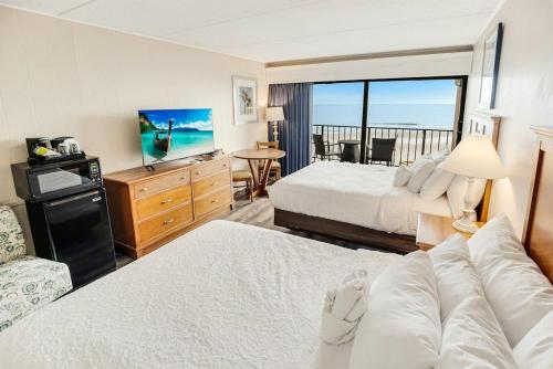 Una habitación de hotel con dos camas y balcón. en Glittering Oceanfront Room 3rd Flr, en Pawleys Island