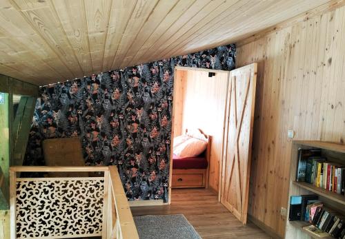 Zimmer mit einer Wand mit Blumentapete in der Unterkunft Agroturystyka 3 chaty red black I nanna in Młynary