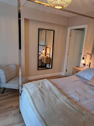 a bedroom with a large bed and a mirror at Sea View Apartment with Balcony & Beautiful Views in Gibraltar