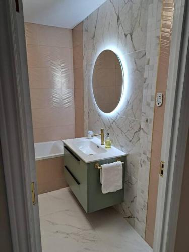 a bathroom with a sink and a mirror and a tub at Sea View Apartment with Balcony & Beautiful Views in Gibraltar