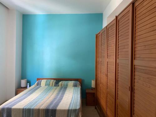 1 dormitorio con cama y pared azul en MARCOLINI - South Beach - Copacabana, en Río de Janeiro