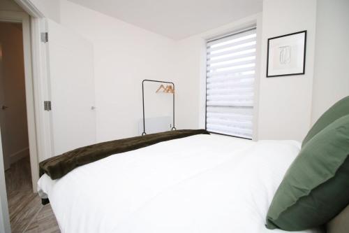 スウィンドンにある2 BR with Free Parkingの窓のある部屋にある白いベッド