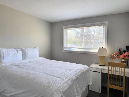 - une chambre avec un lit blanc et une fenêtre dans l'établissement Cozy Home in Niagara-on-the-Lake, à Niagara on the Lake