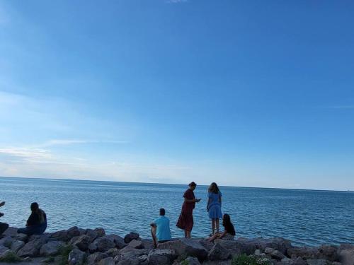 a group of people standing on the rocks by the water at Cozy Home in Niagara-on-the-Lake in Niagara on the Lake