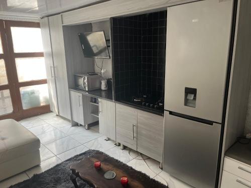 a kitchen with a tv and a table in it at An elegant stay away from home in Johannesburg