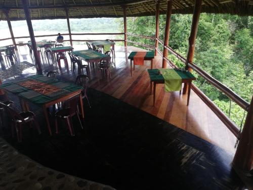um restaurante com mesas e cadeiras numa varanda em Apu Napo Lodge & Reserve em Mondaña