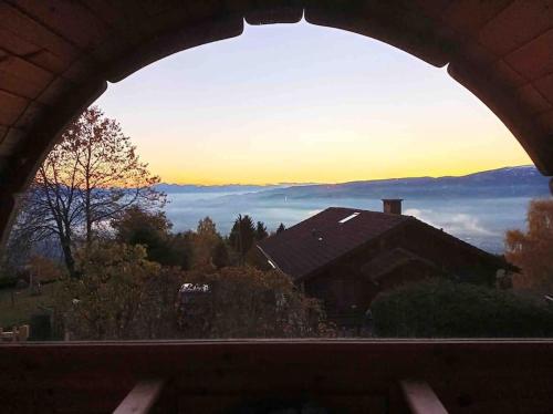 a view from an archway of a house with the sunset at Ferienhaus Almzeit Koralpe in Rieding
