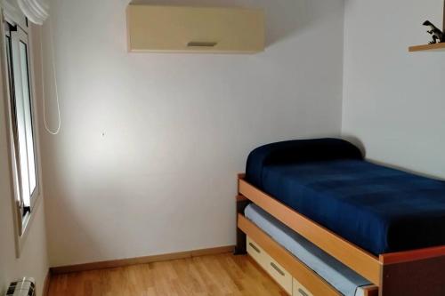 een slaapkamer met een bed met een blauwe matras bij Apartamento céntrico cerca de la playa in Malgrat de Mar