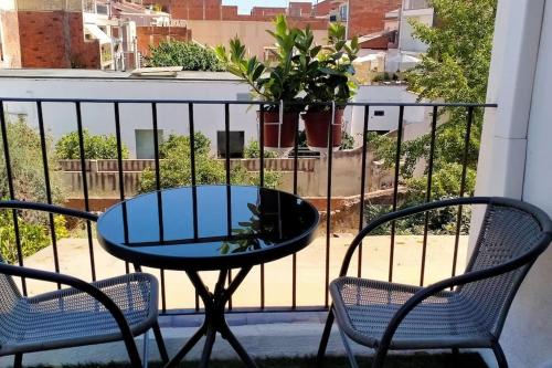 een tafel en 2 stoelen op een balkon bij Apartamento céntrico cerca de la playa in Malgrat de Mar