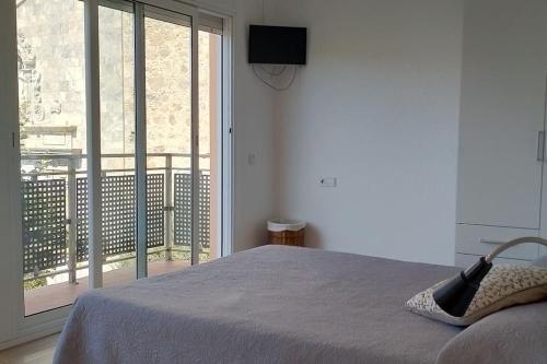 een slaapkamer met een bed en een groot raam bij Apartamento céntrico cerca de la playa in Malgrat de Mar