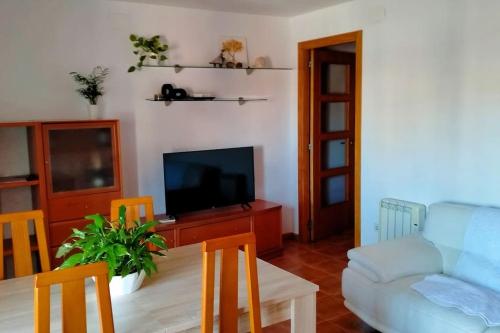 een woonkamer met een blauwe bank en een tv bij Apartamento céntrico cerca de la playa in Malgrat de Mar