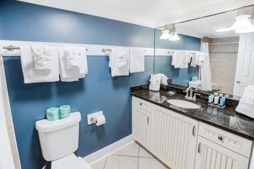 a blue bathroom with a toilet and a sink at Bright and Beautiful Dunes Room 1st Floor in Pawleys Island