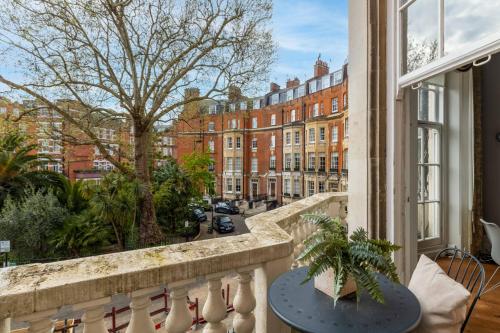 a balcony with a table and a view of a street at Renovu Premium Homes in Kensington in London
