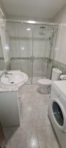 y baño con lavabo, aseo y ducha. en Apartamentos Corea en Portonovo
