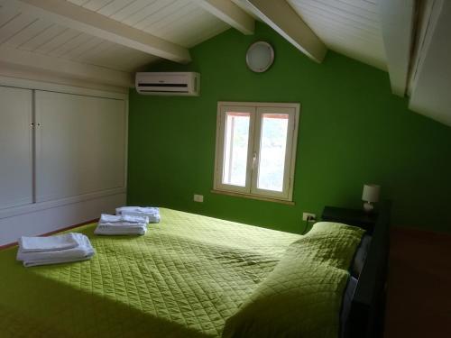 ラスカリにあるVilla Mimmoの緑のベッドルーム(ベッド1台、タオル2枚付)