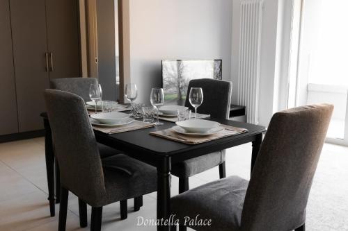 tavolo da pranzo con sedie e bicchieri da vino di Elegant Apartments in Lugano a Lugano