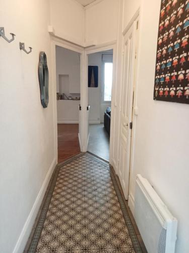 a hallway with a phone hanging on a wall at Logement spacieux et lumineux in Montceau-les-Mines