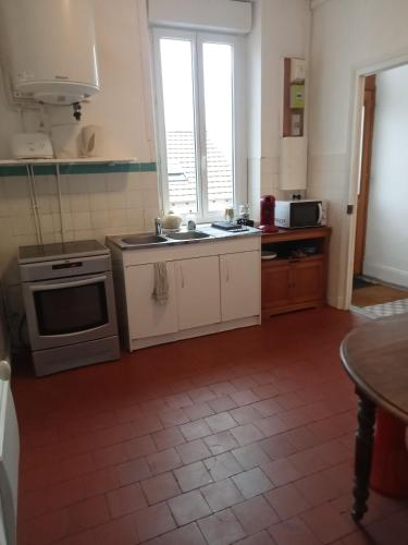 a kitchen with a sink and a stove top oven at Logement spacieux et lumineux in Montceau-les-Mines