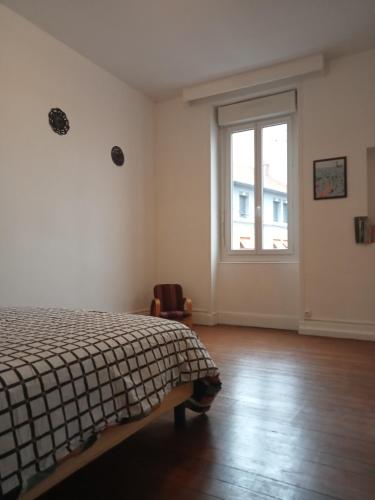 an empty bedroom with a bed and a window at Logement spacieux et lumineux in Montceau-les-Mines