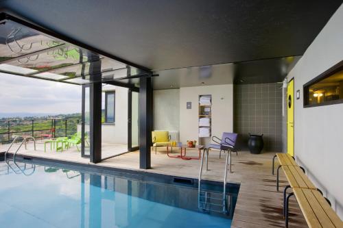 a house with a swimming pool and a patio at L'Ermitage Hôtel Cuisine-À-Manger in Saint-Cyr-au-Mont-dʼOr