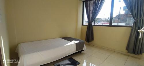 een kleine slaapkamer met een bed en een raam bij 2112 in Pereira