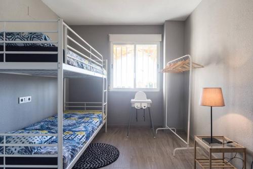 1 dormitorio con 2 literas y ventana en Golf Lucentum, en Alicante