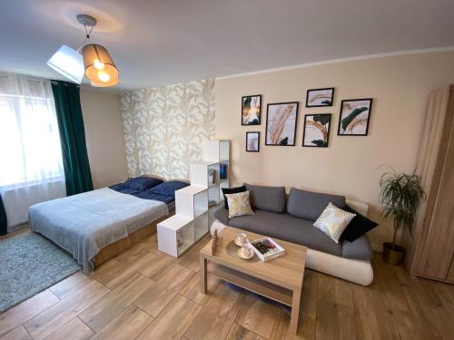 um quarto com uma cama e um sofá num quarto em Mokka Apartament em Varsóvia
