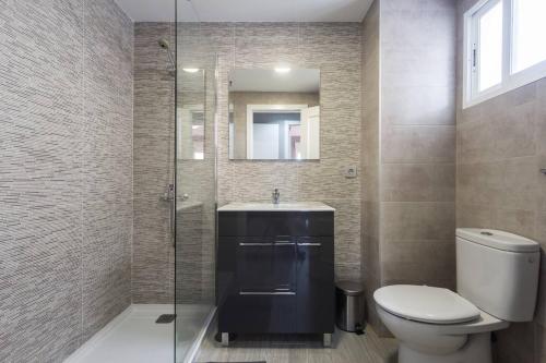 W łazience znajduje się toaleta, umywalka i lustro. w obiekcie Golf Lucentum w Alicante