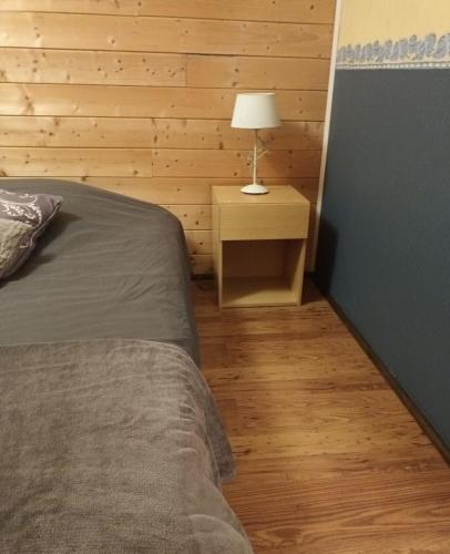 - une chambre avec un lit et une lampe sur une table de chevet dans l'établissement Tête d'Or Forest, à Villeurbanne