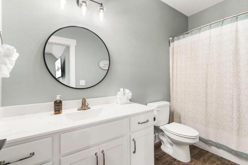 a bathroom with a sink and a toilet and a mirror at Near Indoor & Outdoor Pools: Hot Tub, Game Room & Free SDC Tickets in Kimberling City
