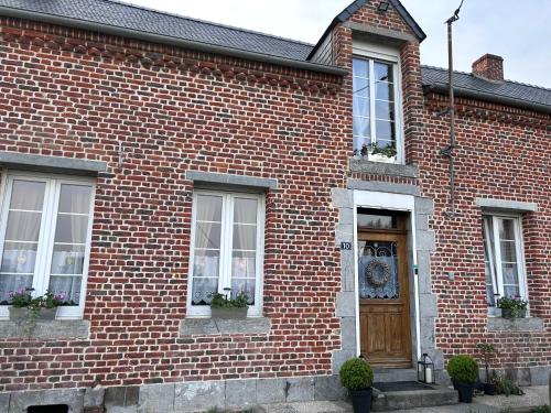 a brick house with a wooden door and windows at Le Terrier du sorcier in Floyon