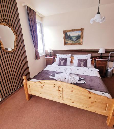 a bedroom with a large bed with a wooden frame at Hotel Elisabeth Ilse in Braunlage