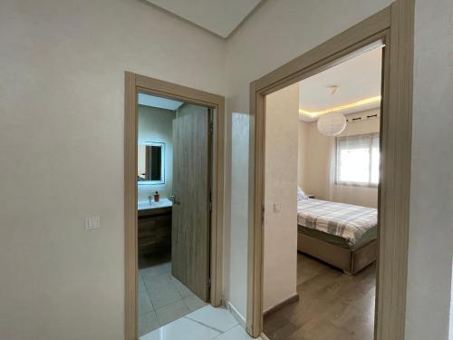 a bedroom with a bed and a bathroom with a mirror at Grand Studio résidence neuve avec piscine in Casablanca