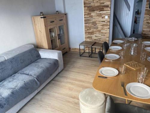 - un salon avec une grande table et un canapé dans l'établissement Appt La Mongie pied des pistes avec vues montagne, à Bagnères-de-Bigorre