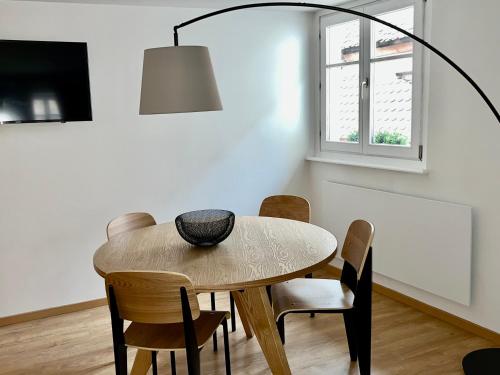 une salle à manger avec une table, des chaises et une lampe dans l'établissement Le grand rue, à Strasbourg