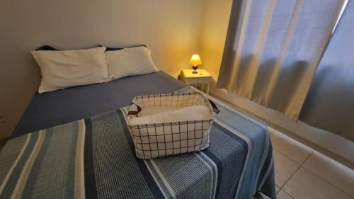 a bedroom with a bed with a basket on it at Apartamento Confortável e Espaçoso in Sinop