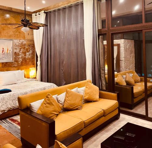 een woonkamer met een bank en een bed bij Hotel "ala Residencias" in Chetumal