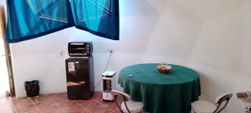 Habitación con mesa y mantel verde en Hermoso Domo privado para 2 personas con tinaja-Cochiguaz Valle De Elqui, en Paihuano