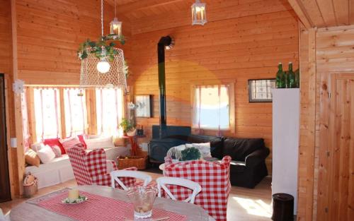 a living room with a couch and a table and chairs at Carmeta - Casa Rural de madera con jardín, piscina privada y barbacoa - Deltavacaciones in L'Eucaliptus