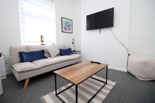 un soggiorno con divano e tavolo di Bristol Street 2 BR FREE onsteet parking a Newport