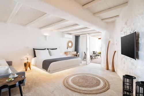 a hotel room with a bed and a tv at White Stone Mykonos in Agios Ioannis Mykonos
