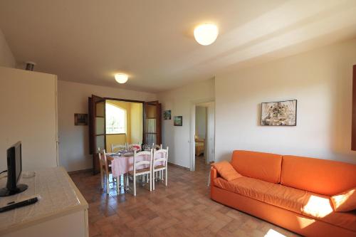 a living room with an orange couch and a table at Borgo Etrusco in Scarlino