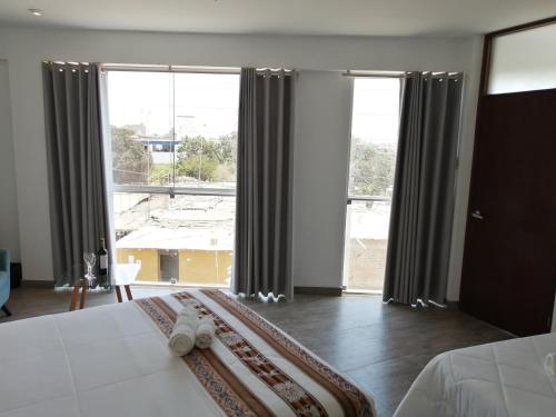 sypialnia z łóżkiem i dużym oknem w obiekcie Casa Yuraq Hotel Boutique w mieście Chincha Alta