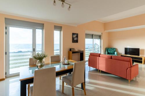 a living room with a red couch and a table at Villas do Mar in Faja Grande