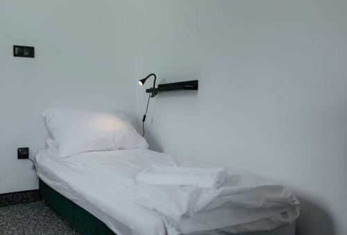a bed in a room with a light on it at Pokoje Na Winklu in Kluszkowce